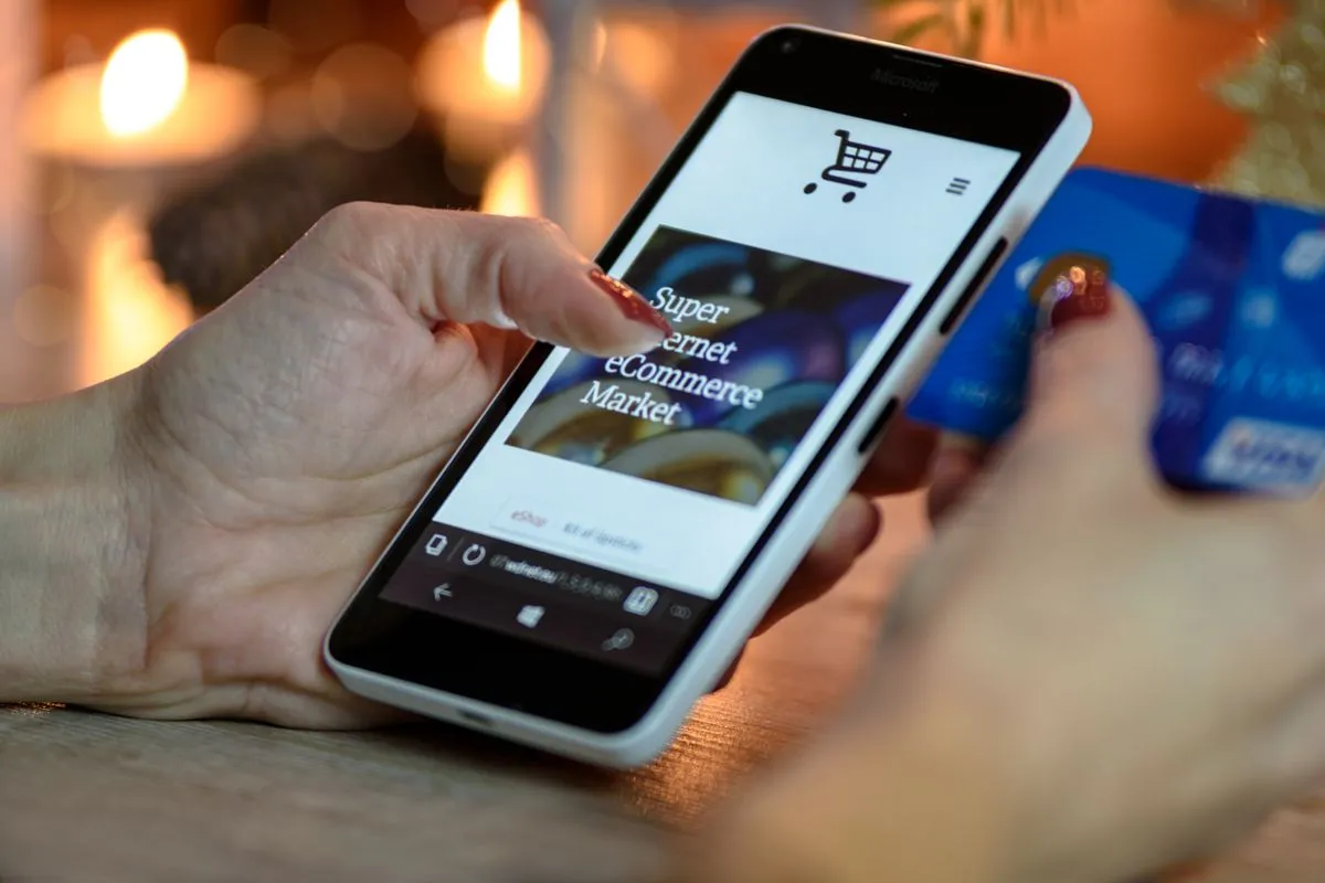 Hand som handlar i en webbutik på en smartphone — de flesta kunder besöker din hemsida via mobilen.